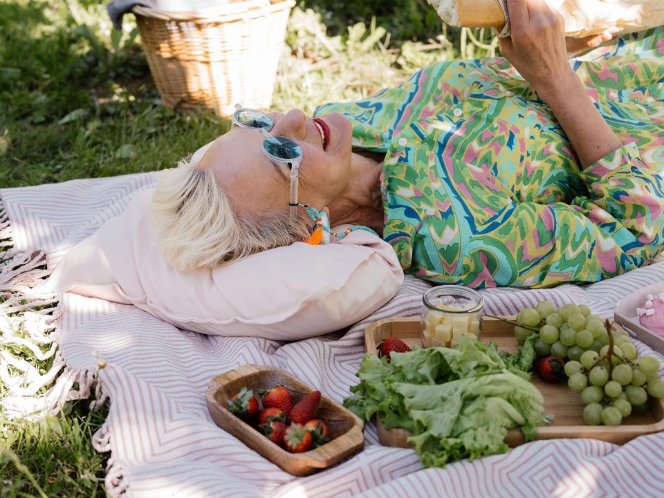 Woman over 40 enjoying a peaceful garden picnic, embracing self-acceptance, life balance, and letting go of stress.